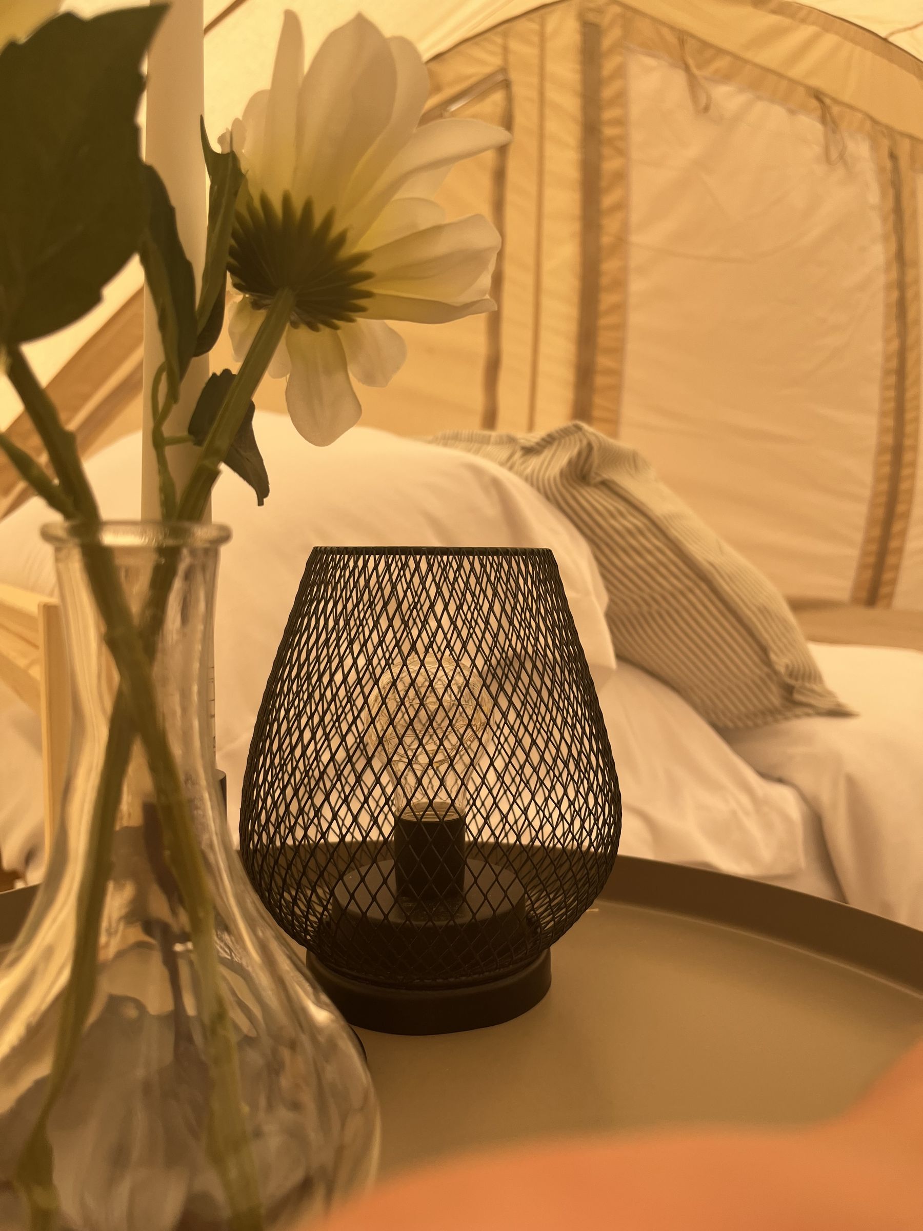 A bedside table with a lantern and cut flowers